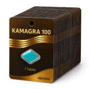 Brown and gold medicine packaging for Kamagra 100 tablets, with a blue KGR 100 tablet label visible and Ajanta branding at the bottom.